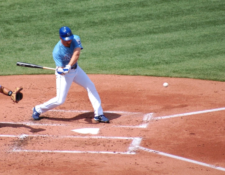 a baseball player swinging a bat at a ball