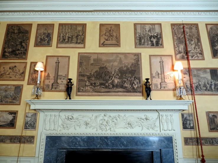 a mantle covered in pictures next to lamps