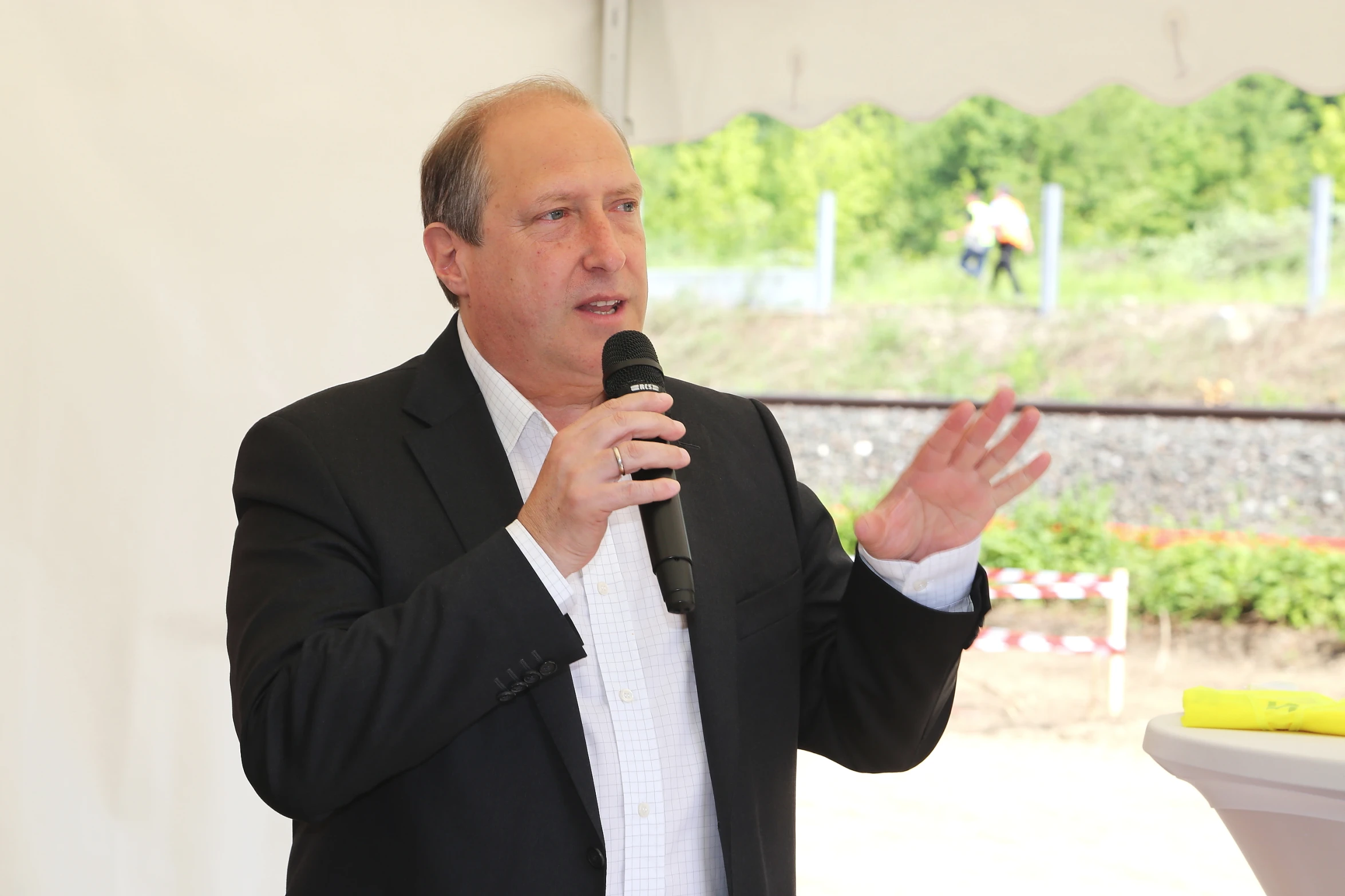 a man standing and giving a speech to people