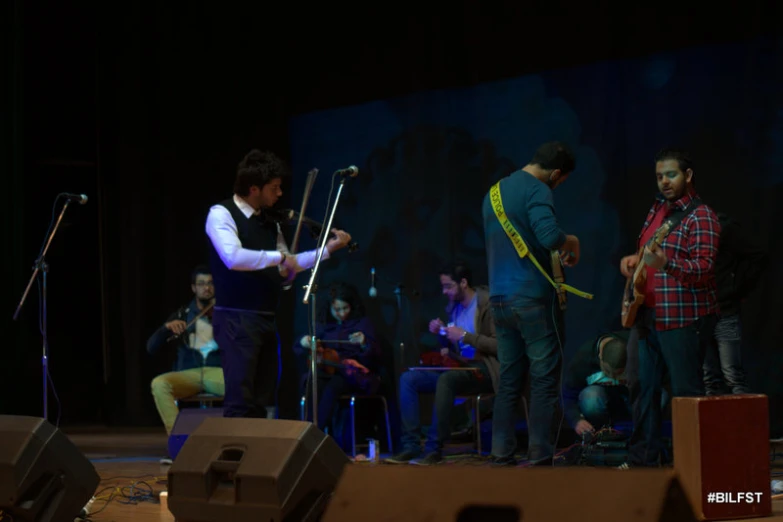 a man on stage playing instruments for other people