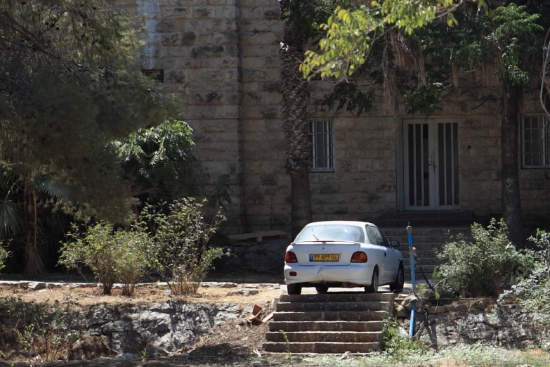 a car parked on the road near stairs