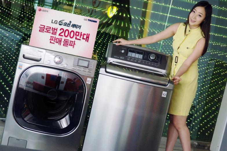 a lady standing next to a stack of appliance and washing machine