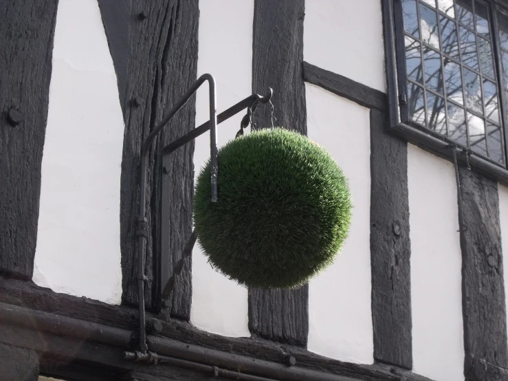 a round ball is hanging from the ceiling in front of an old building