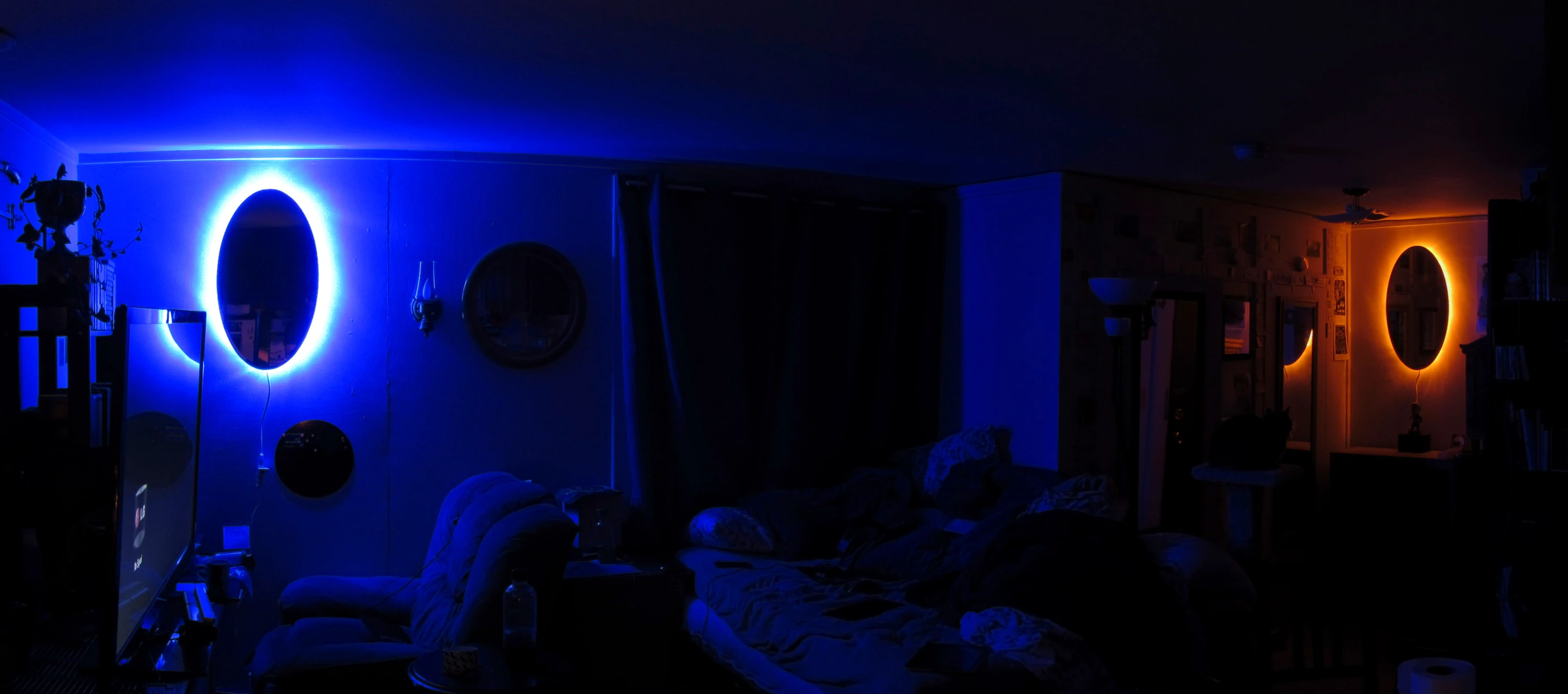 a living room with bright blue lights on the wall