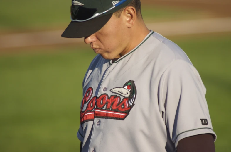 a baseball player on the field holding his cap