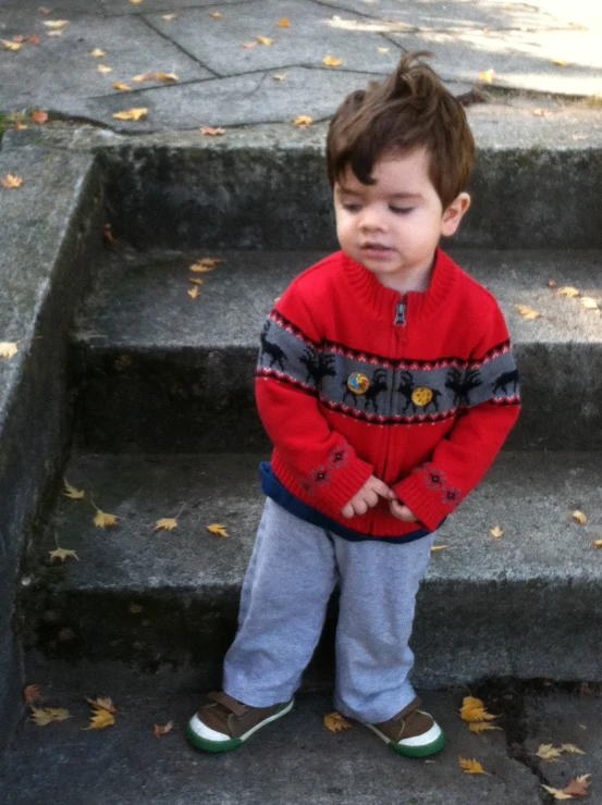 a toddler standing on the steps staring