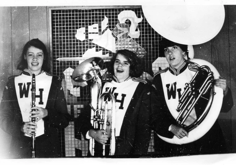 a black and white po of five women holding trophies