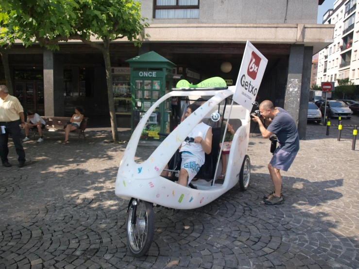 a man taking a po of a small vehicle