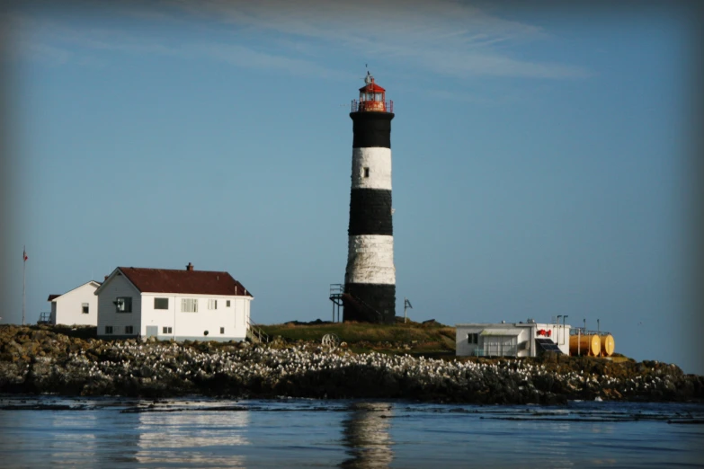 a black and white lighthouse next to a house