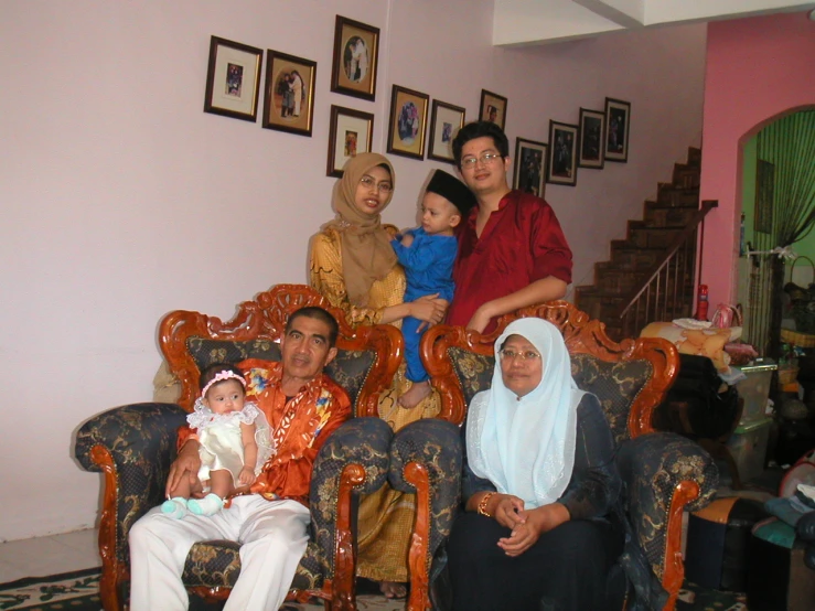 a family with three children sitting on chairs