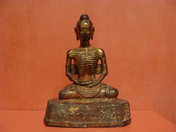 a gold statue of a seated person