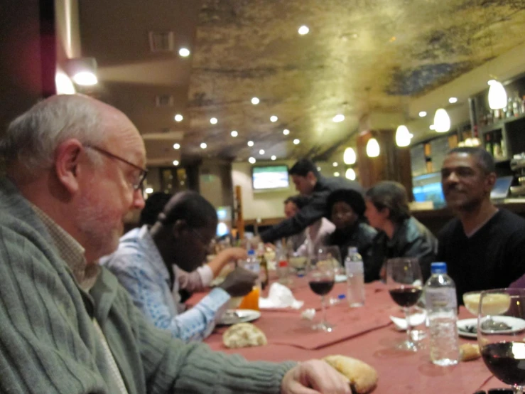 a group of people sitting at a restaurant table having a meal