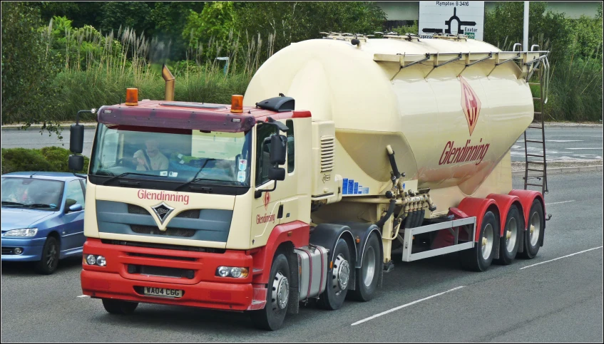 an orange, yellow and red concrete mixer on the road