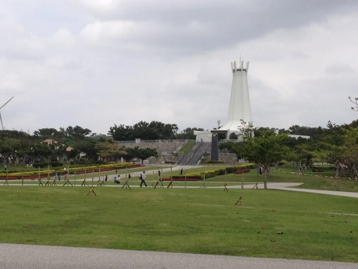 people in a large field near a memorial