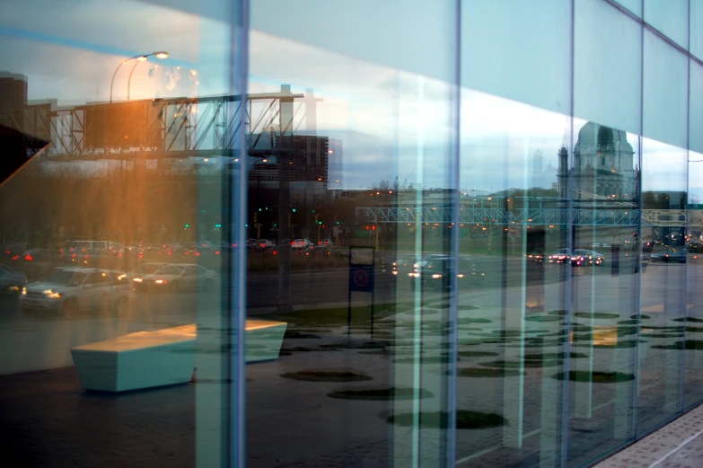 this is a reflection of a building with buildings and cars in the windows