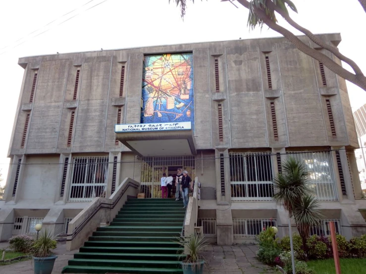a building with stairs leading up to a stairwell and large mural on the wall
