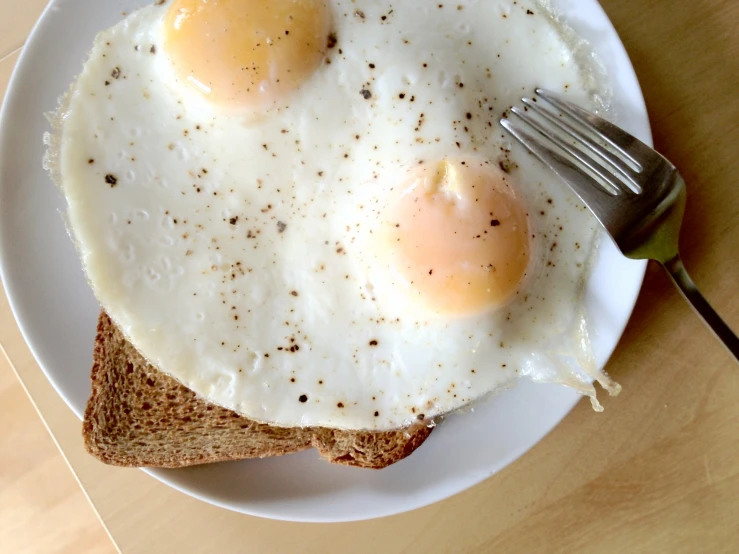 an egg is placed on top of a toast with a fork