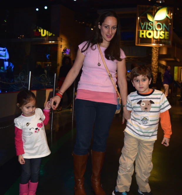 two little s and a young woman on rollerblades