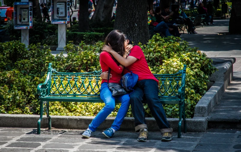 a pair of people who are sitting on a bench