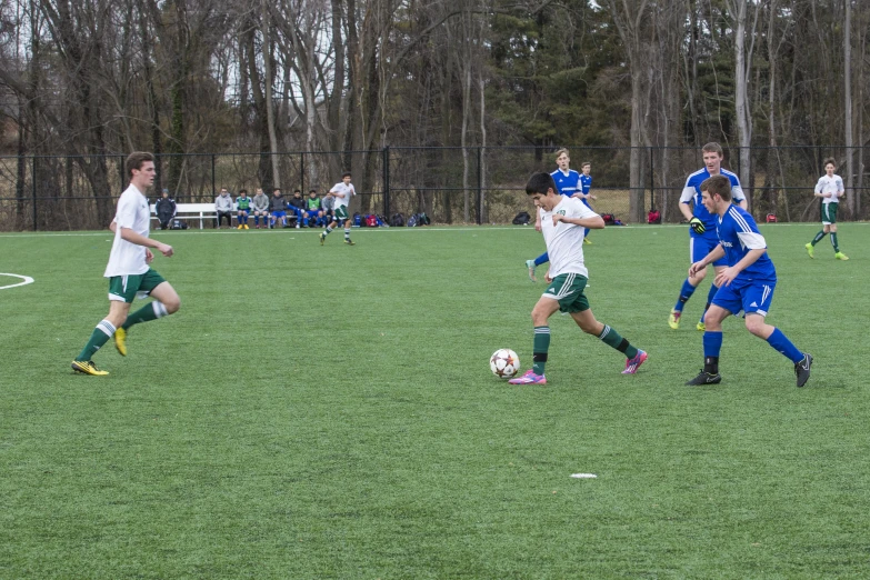 several players run around a soccer ball on a field