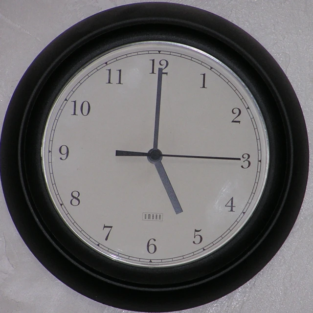 a clock on a wall has black trim around the numbers
