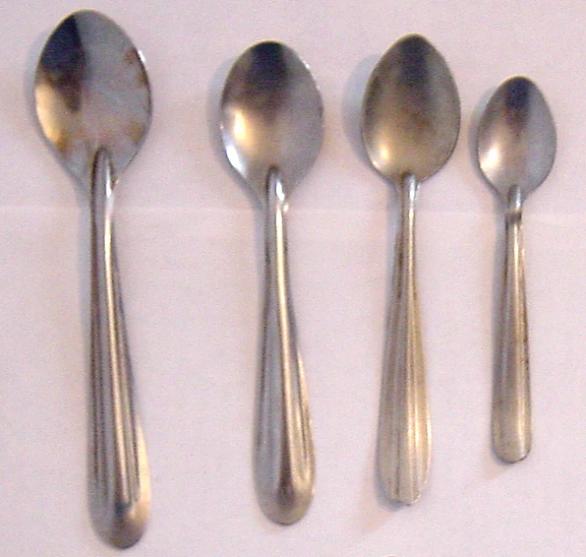 an array of silver colored spoons lined up