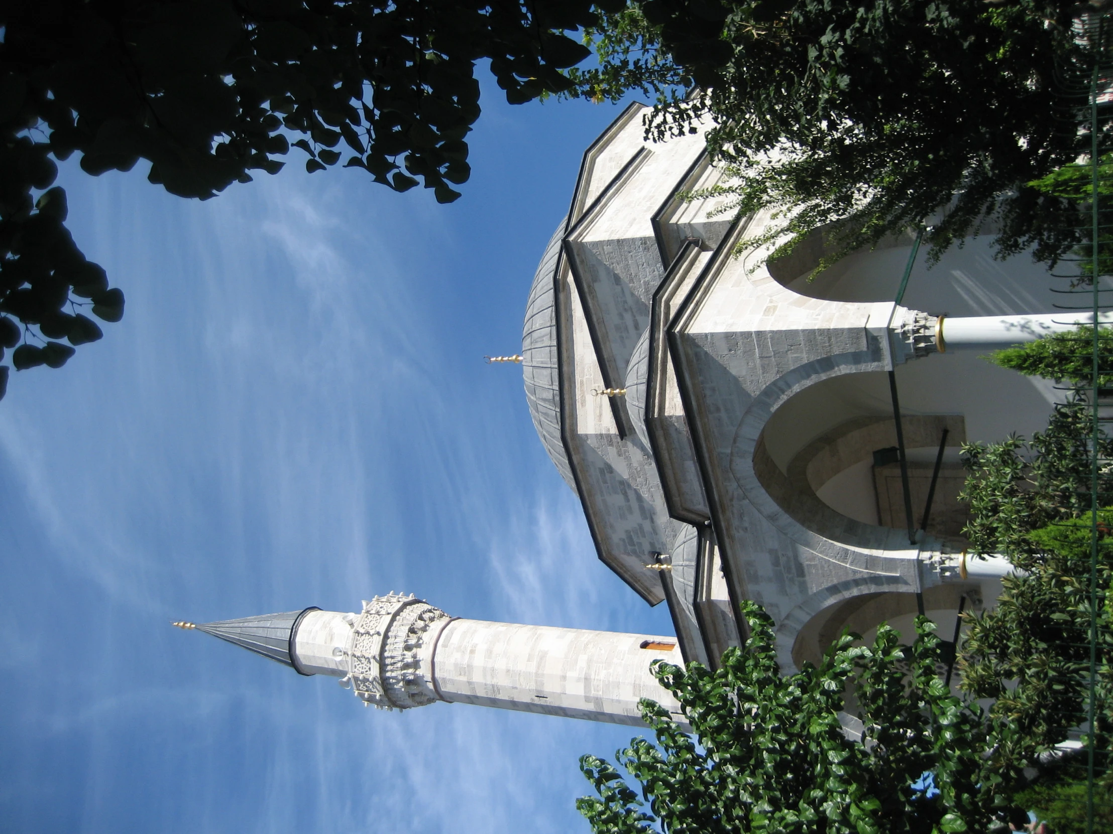 a tall grey and white building with arches