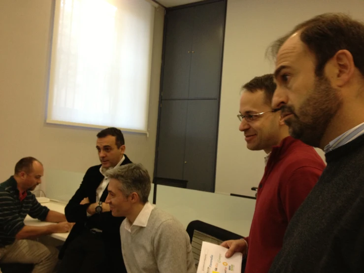 a group of men standing around at a table