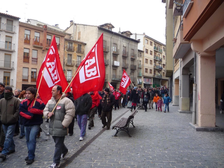 a crowd of people marching through a town