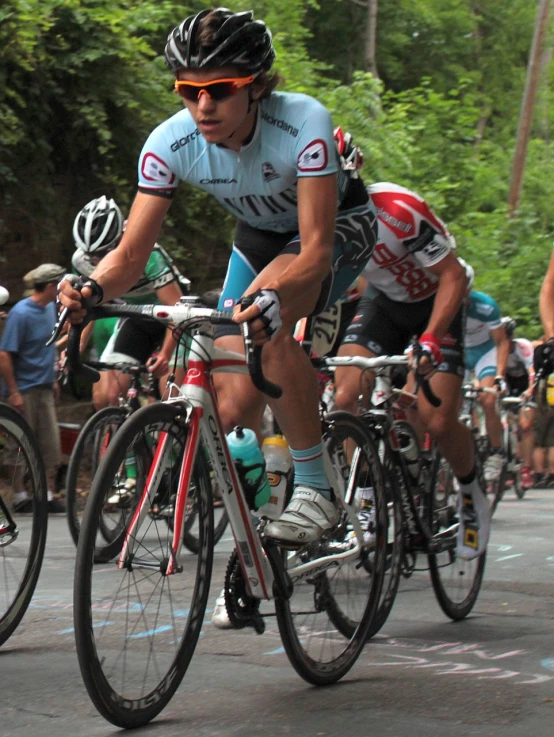 men riding their bikes down a paved street