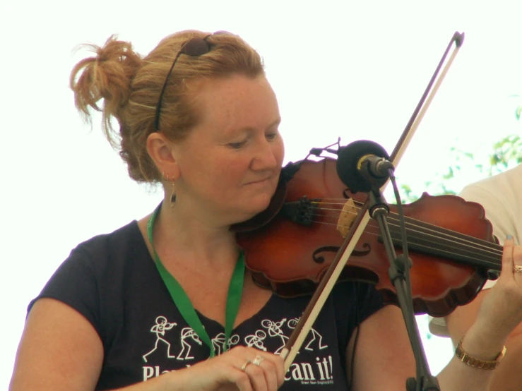 a girl playing violin on a stage with an adult