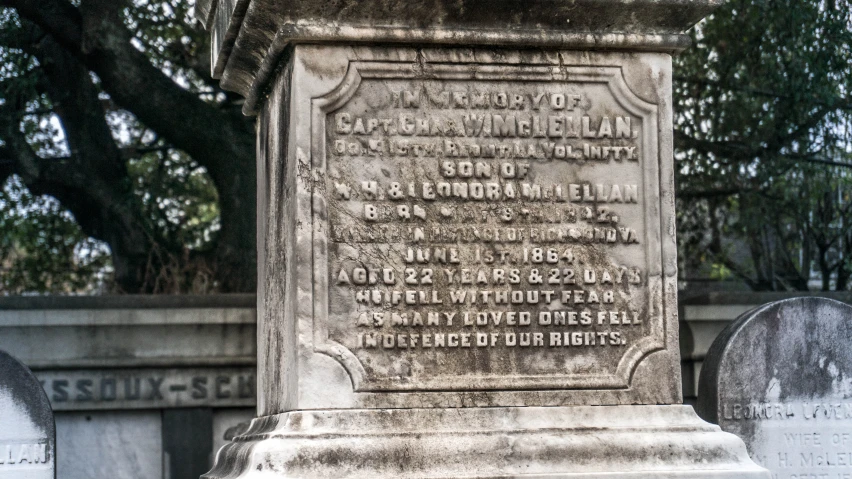 a monument in the middle of a cemetery with writing on it