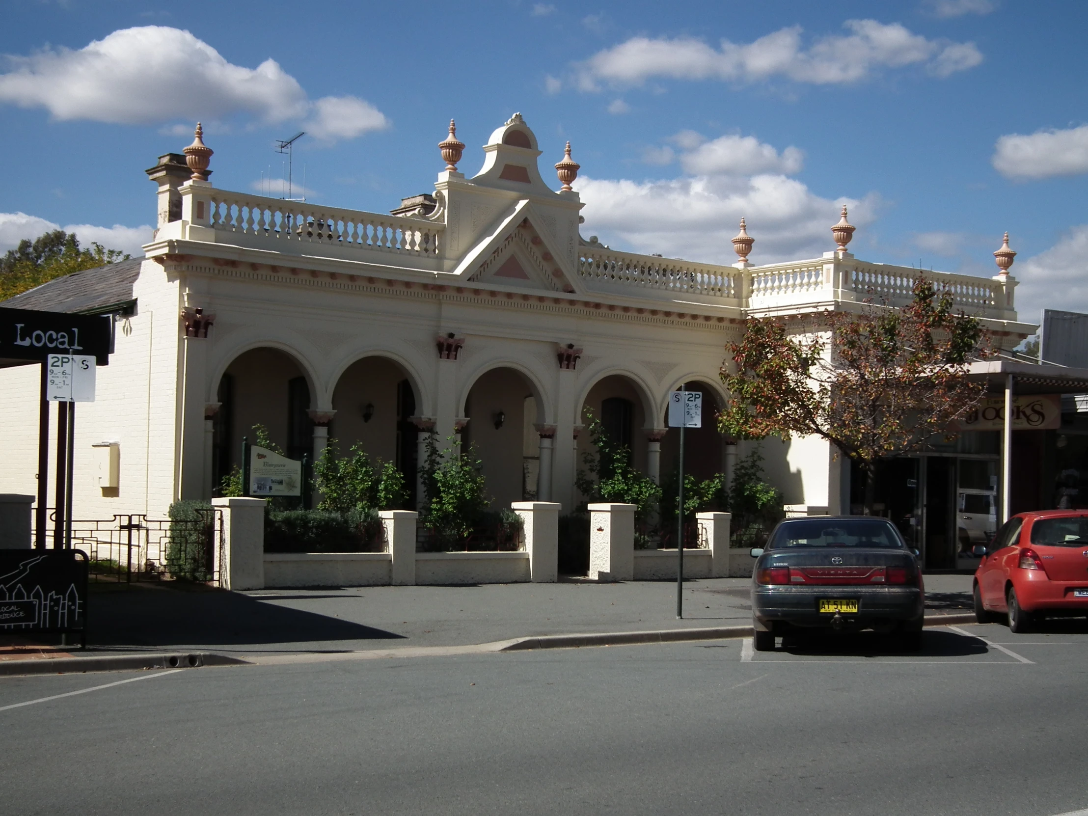 cars are driving past a building near the street