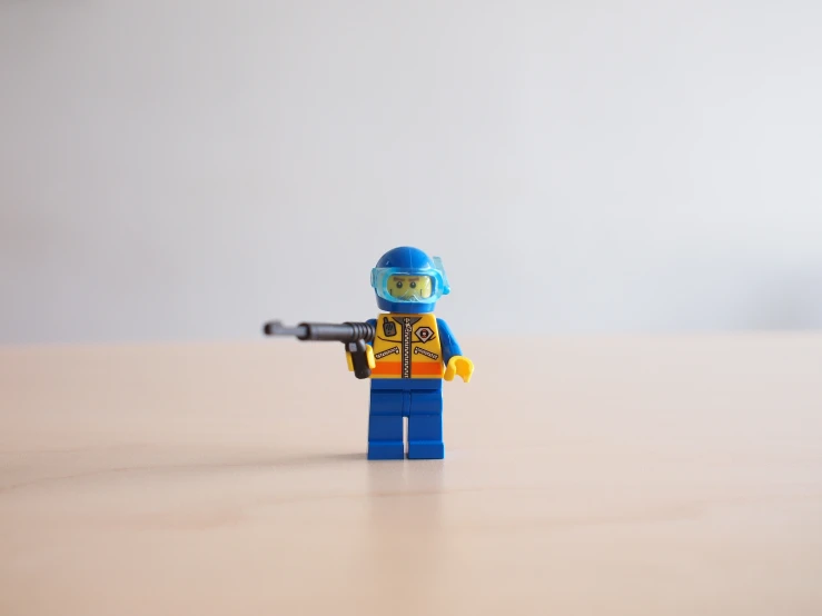 a lego figure holding a gun on top of a table