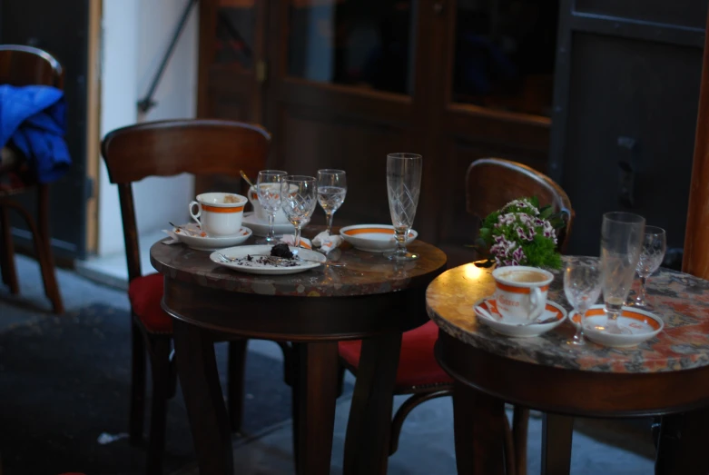 a table topped with plates and cups next to a window