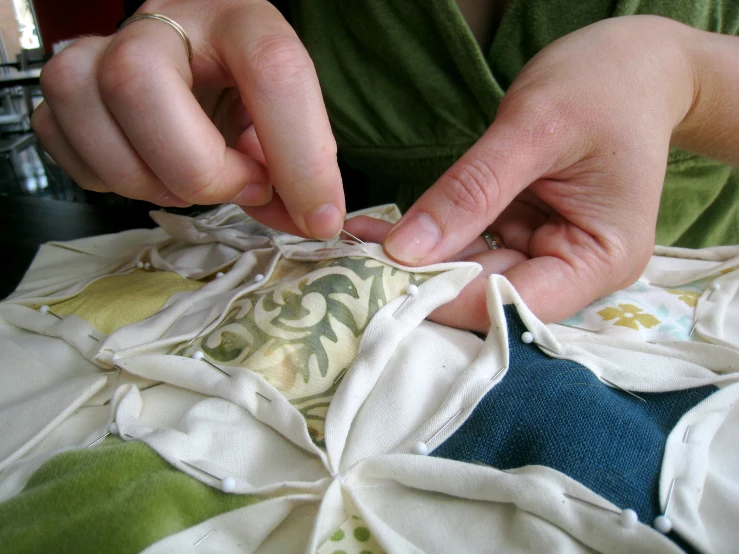 a woman stitchesing material with her finger