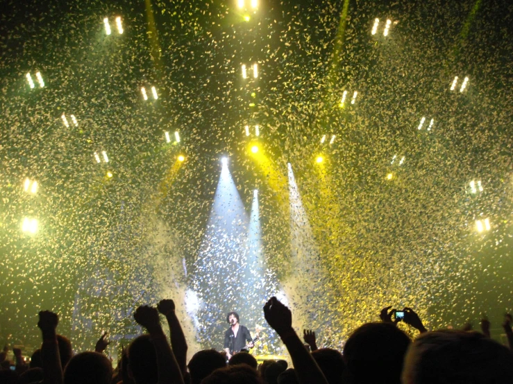 crowd watching stage lights and confetti over stage