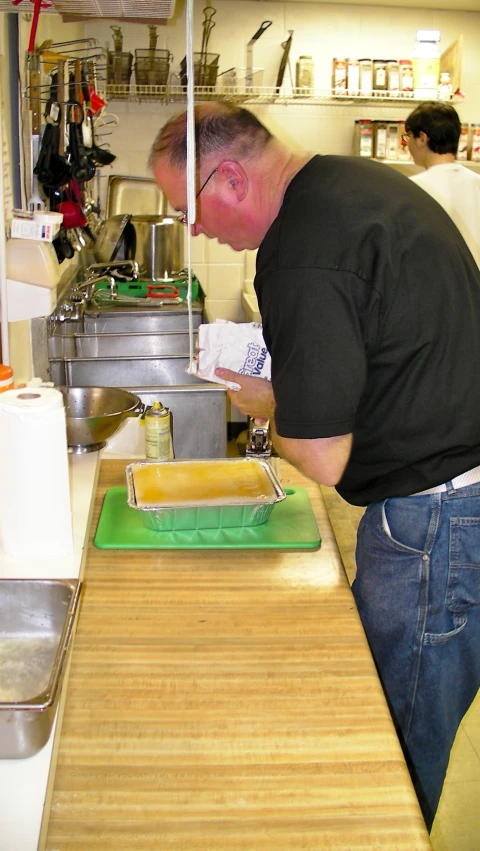 there is a man making some food at the counter