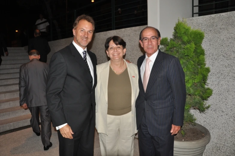 three people standing next to each other in a suit