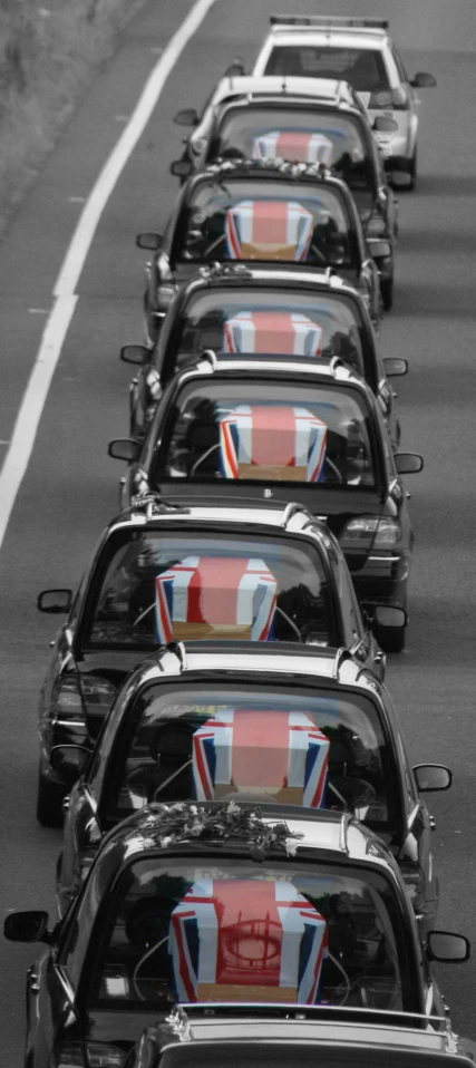 several cars with british flags on them on a street