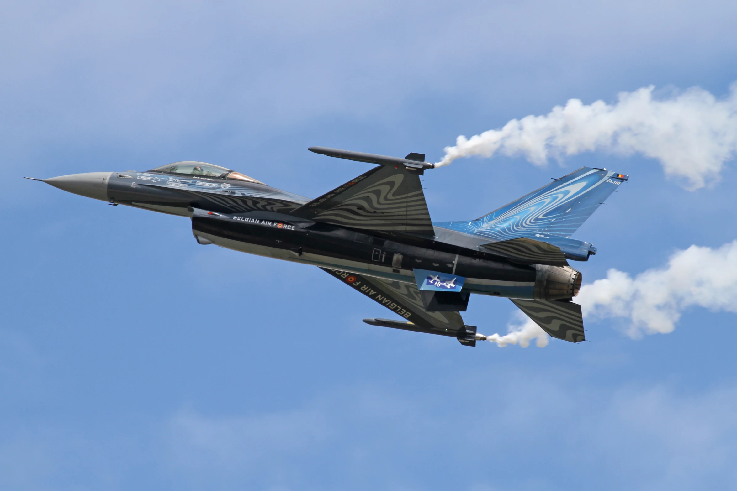 a fighter jet with smoke coming out of the top