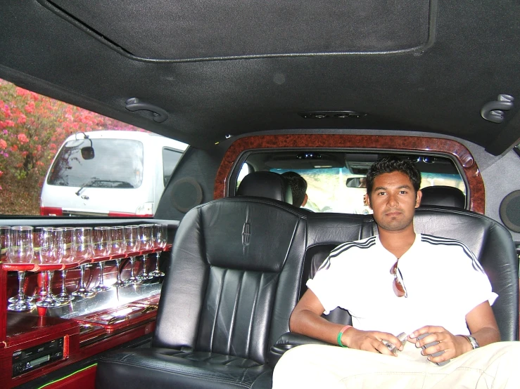 a man sitting in a car with a bunch of bottles