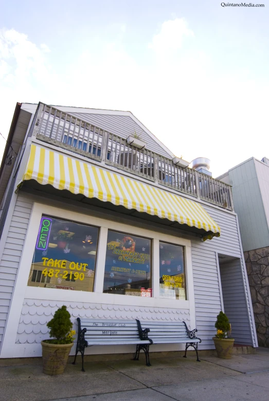 the front of a store with striped awnings