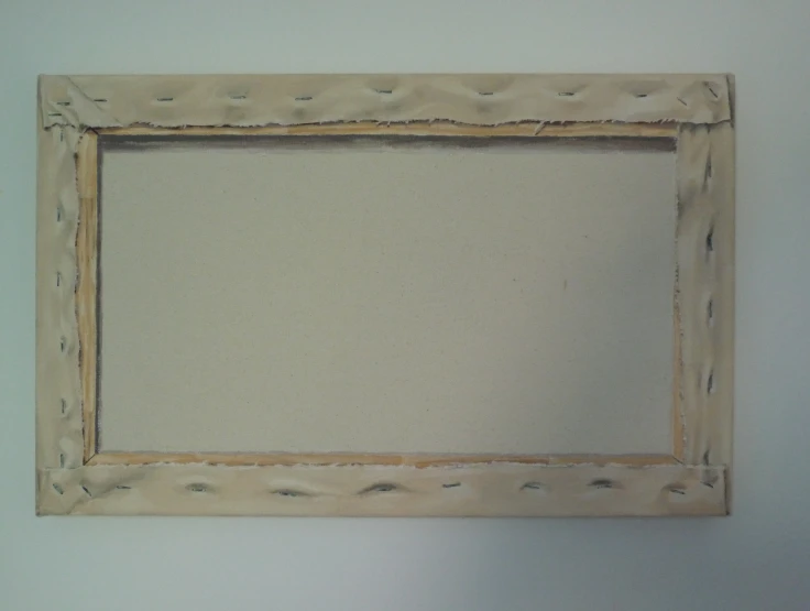 an empty wooden frame is hung on the wall