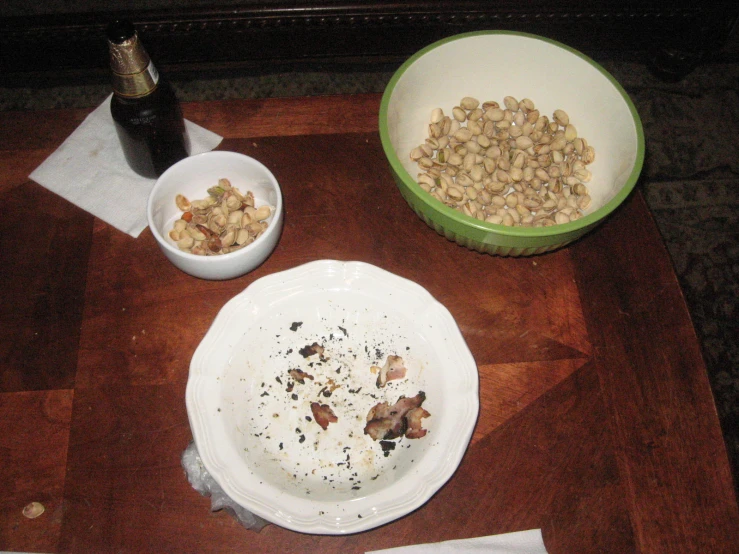 an empty bowl of nuts is left by two plates
