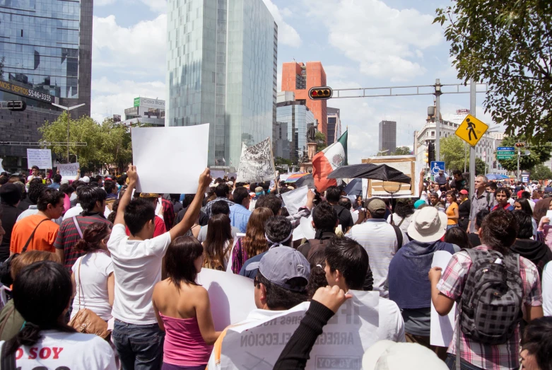 a group of people with a sign standing on the side walk