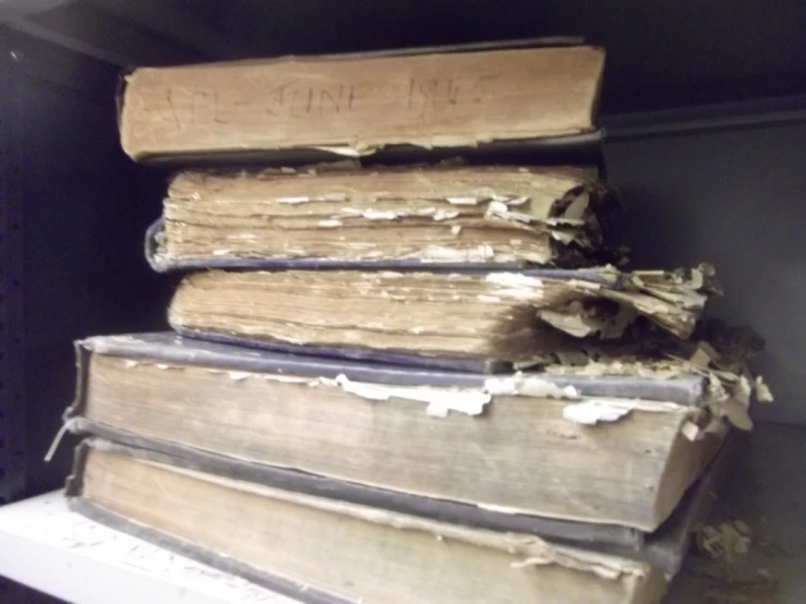 a shelf with old books stacked high up on it