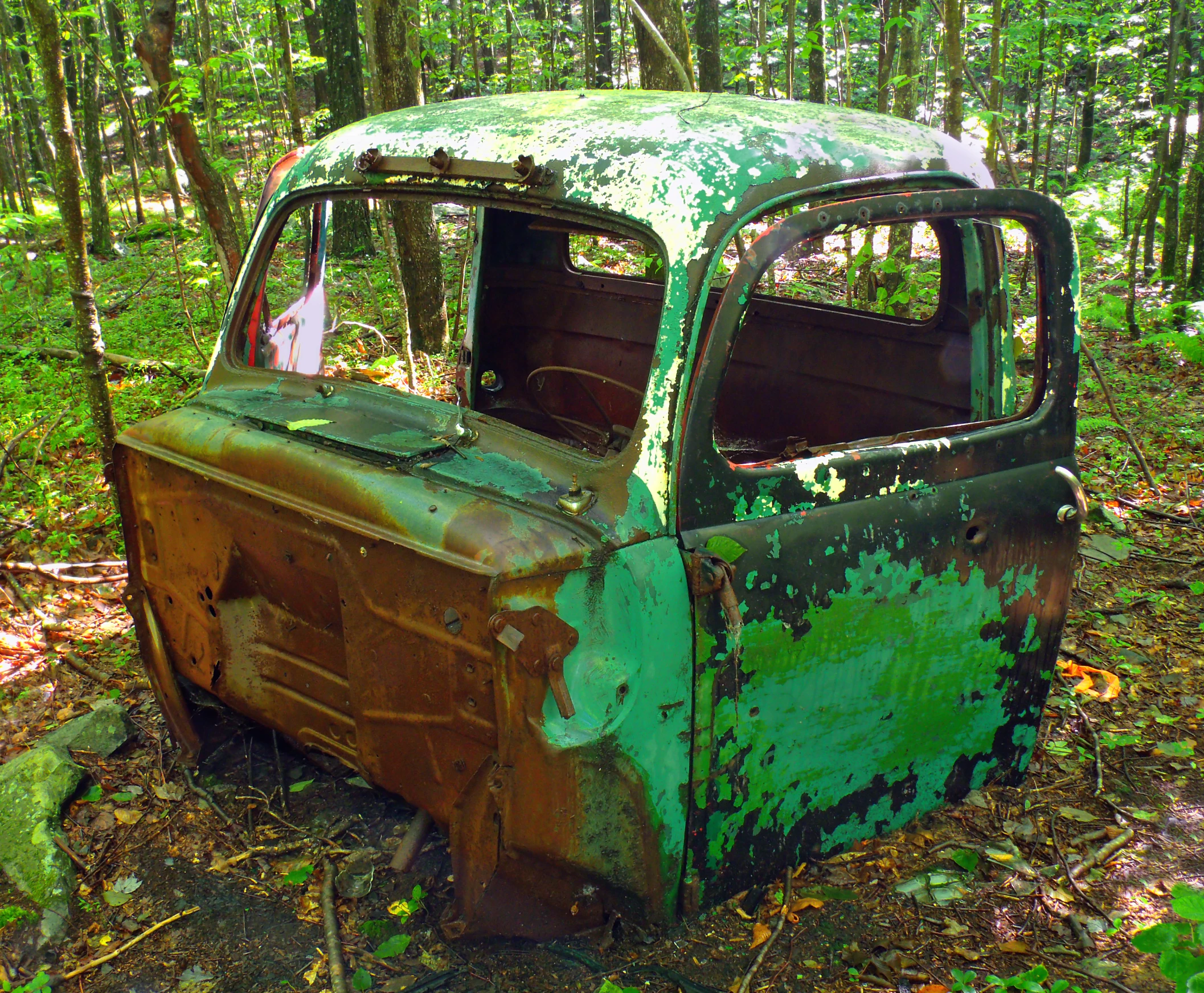 an old pick up truck in the middle of a forest