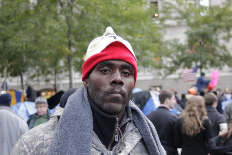 man in camouflage jacket and red white and blue hat