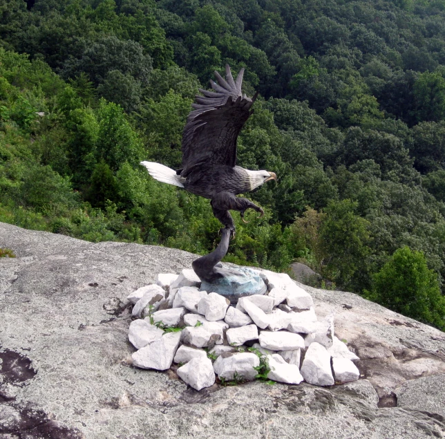 an eagle sculpture is in the middle of a pile of rocks